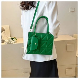 Detail of emerald green quilted crossbody tote bag with a small matching coin purse pouch
