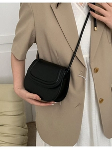 Minimalist black saddle bag in matte leather with golden hardware for elegant women