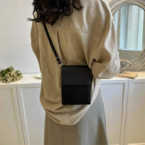 Petit sac à bandoulière minimaliste en cuir noir avec rabat et bandoulière réglable