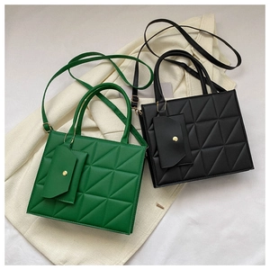 Flat lay of stylish triangle quilted crossbody bags in green and black with mini pouches