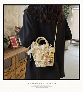 Close-up of beige straw bag with daisy embroidery and elegant white lace bow detail