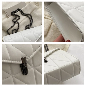 Vue détaillée de la texture cuir matelassé blanc avec chaîne en métal et fermoir