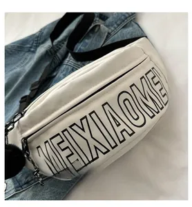 Detailansicht der großen weißen Brusttasche mit schwarzem MEIXIAOMEI-Text und Pompon-Anhänger