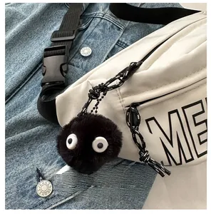 Detail eines süßen schwarzen Plüsch-Anhängers mit großen Augen an weißer Canvas-Tasche