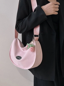 Pink crescent nylon shoulder bag with a strawberry pendant and wide strap