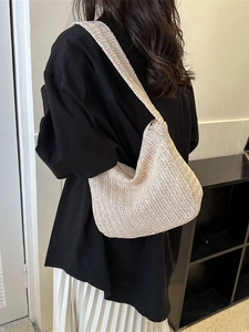 Chic beige straw woven tote bag with V-shaped texture shown on a female model