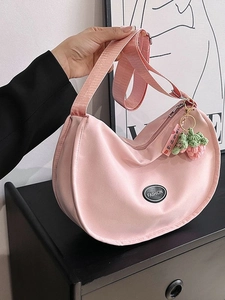 Pink crescent shoulder bag with wide strap and strawberry pendant for casual wear