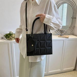 Fashionable black quilted tote bag with matching mini pouch and adjustable strap for women