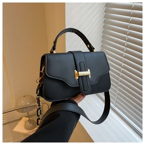 Detail of black crossbody bag with gold H buckle and stylish thick chain strap decoration