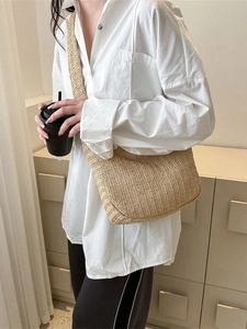 Large straw crossbody tote bag with natural woven texture and wide shoulder strap