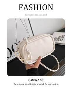 Detail of cream minimalist crossbody bag with resin chain and embossed fashion text