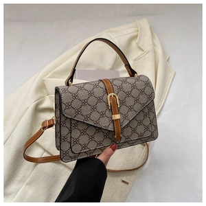 Detail of vintage tote bag featuring floral patterns, leather handles and gold metal clasp