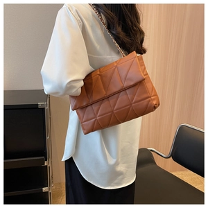 Borsa a tracolla trapuntata marrone con catena dorata indossata da modella in interno