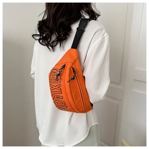 Detail der leuchtend orangen Brusttasche mit schwarzem Buchstabendruck und verstellbarem Gurt