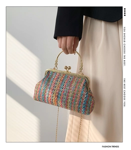 Detail of multi-color woven shell bag with vintage gold engraved metal handle and chain