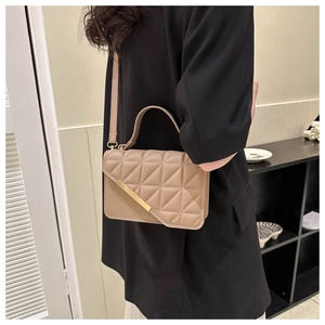 Modella con borsa a mano trapuntata kaki con barra metallica e tracolla regolabile