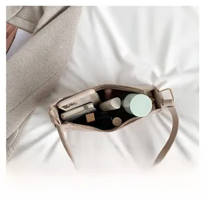 Top view of beige baguette bag showing internal capacity with phone and cosmetics