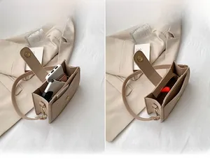 Detail view of the interior capacity of a beige croc-embossed felt shoulder bag for women