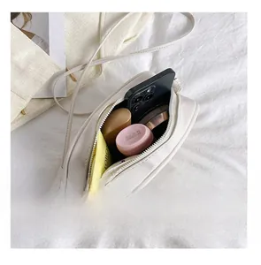Detail presentation of interior capacity for cream crossbody bag showing daily essentials