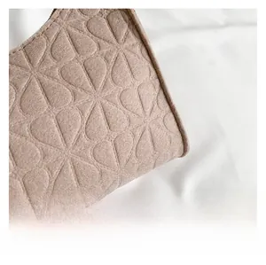 Close-up of heart floral embossed felt fabric on light brown underarm shoulder bag
