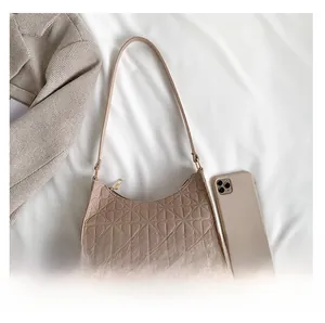 Detailed view of beige hobo bag with geometric heart embossing on soft felt fabric