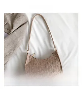 Detail view of taupe felt bag featuring embossed floral patterns and golden zipper closure