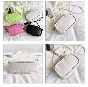 Detail view of four minimalist square bags with chain accents and embossed fashion lettering