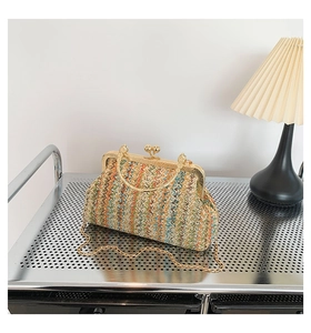 Detail of colorful woven wave pattern with golden metal frame and chain on a shell bag
