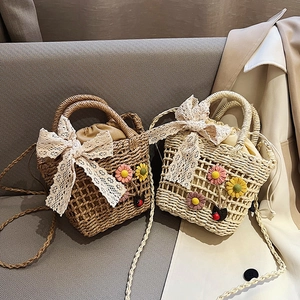 Handmade woven straw bag with lace bow and floral charms in a cozy lifestyle setting