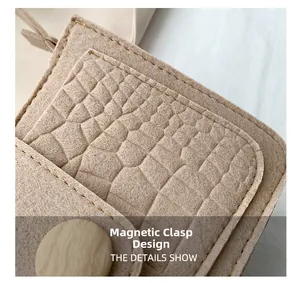 Macro shot of khaki felt bag showing crocodile texture, gold stitching and magnetic closure