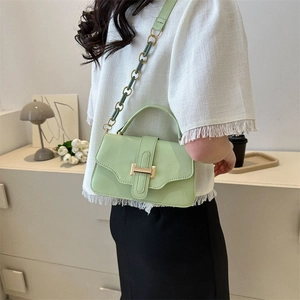 Minimalist mint green crossbody bag with gold buckle shown from a stylish side angle