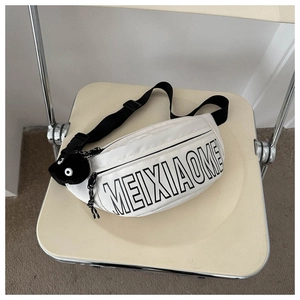 Nahaufnahme der weißen Nylon-Gürteltasche mit schwarzem Buchstabendruck und Plüschanhänger