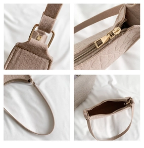 Detail of beige felt shoulder bag showing golden zipper and quilted geometric texture