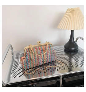 Detail of colorful woven chain bag with gold metal clasp on a silver display cart