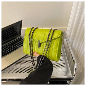 Détail du sac à chaîne matelassé vert néon avec fermoir tournant métallique et fini brillant