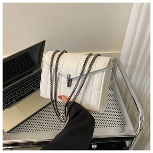 Détail du sac à bandoulière en cuir matelassé blanc avec chaîne et fermoir rotatif