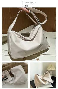Detail view of large cream shoulder bag with smooth glossy finish and zipper closure