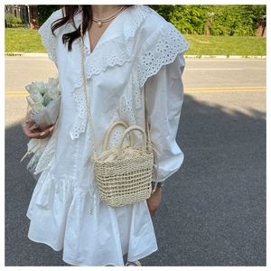 Detail view of mini straw bucket bag with lace lining and woven texture handle
