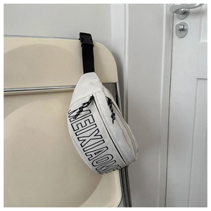 Detail der weißen Canvas-Gürteltasche mit schwarzem Buchstabendruck und Nylonband