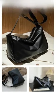 Detail of minimalist black PU leather tote bag with adjustable strap and zip closure