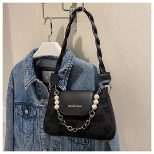 Detail of black leather underarm bag with pearl flower chain and woven shoulder strap
