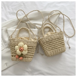 Detail of mini straw bucket bags with drawstring liners and decorative floral charms