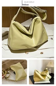 Detail view of a pale yellow soft PU leather hobo bag with wide shoulder strap and metal buckle