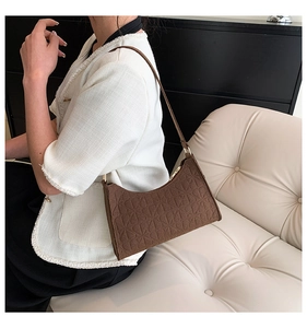 Detail of vintage brown felt baguette bag with embossed geometric floral patterns