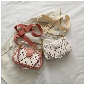 Detail of quilted diamond pattern bags with woven handles and fabric shoulder straps