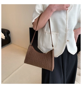 Detail view of the brown felt shoulder bag with textured surface and gold zipper detail