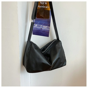 Close-up of black matte PU leather tote bag with stylish pleated design and silver zipper