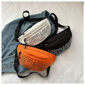 Flache Ansicht von weißen, schwarzen und orangen Gürteltaschen auf Denim-Hintergrund