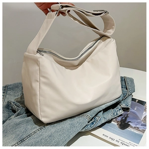 Detail of adjustable wide shoulder strap on cream white crossbody bag with nylon texture