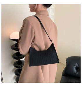 Detail of black felt underarm bag featuring geometric pattern and chic shoulder strap